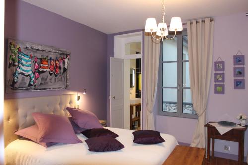 格朗维尔La Maison de Juliette的一间卧室配有带枕头的床