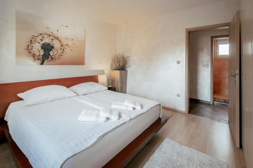 卢布尔雅那Apartments in Villa Olimp的卧室配有一张带白色床单和枕头的大床。