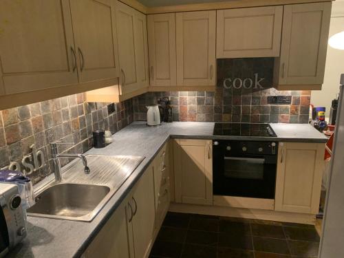 斯丹斯达蒙费雪特Stansted spacious 2-bed apartment, easy access to Stansted Airport & London的厨房配有白色橱柜、水槽和炉灶。