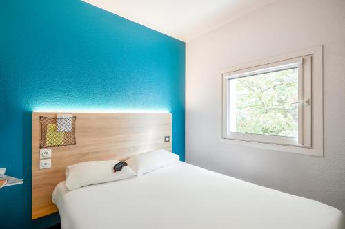尚尼耶HôtelF1 Angoulême的卧室配有白色的床和窗户。