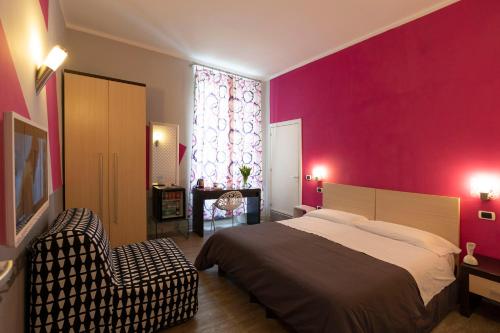 那不勒斯H Rooms boutique Hotel的一间卧室设有一张大床和粉红色的墙壁