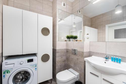 华沙Rakowska 14A 1 bedroom by Homeprime的浴室配有洗衣机、水槽和洗衣机。