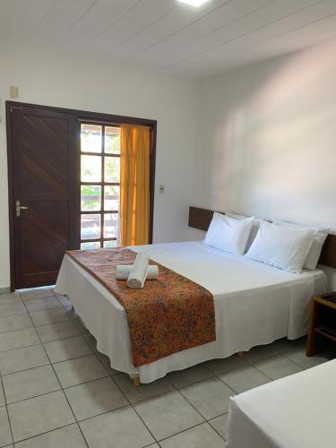 塞古罗港Hotel Monte Pascoal Smart的卧室设有一张白色大床和一扇窗户。