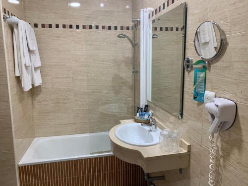 塞维利亚塞维利亚欧罗巴精品酒店的浴室配有水槽、淋浴和浴缸。