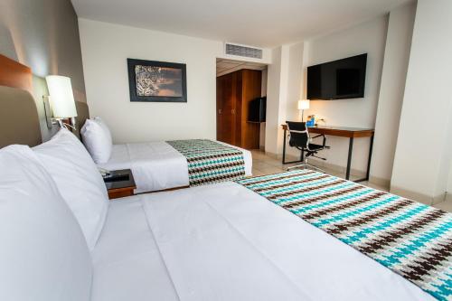 普卡尔帕Costa del Sol Wyndham Pucallpa的酒店客房配有两张床和一张书桌