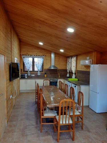 卡马尔莱斯Caseta De L'avi的厨房配有桌椅和冰箱。