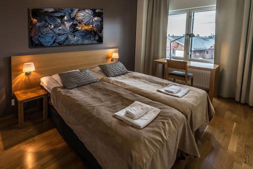 鲁卡Ruka Chalets Ski-Inn的酒店客房设有两张床和窗户。