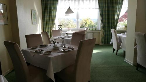 Bad Eilsen兰德豪斯拉曼酒店的一间带桌椅和窗户的用餐室