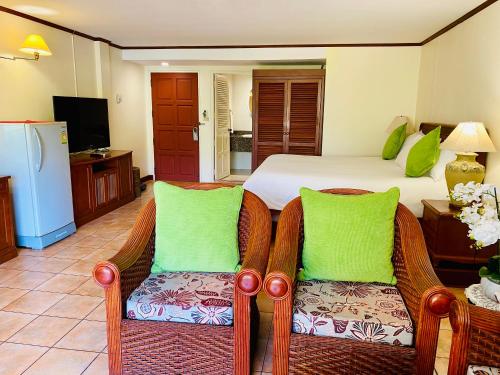 苏林海滩苏林湾旅馆的一间卧室配有一张床和两张藤椅