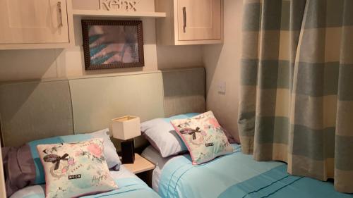 SwarlandWoodland Retreat的小型客房配有2张单人床和窗帘