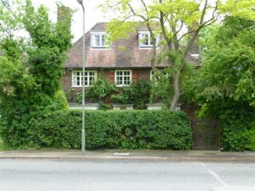 伦敦洛兰希酒店的红砖房子,有灌木丛和街道