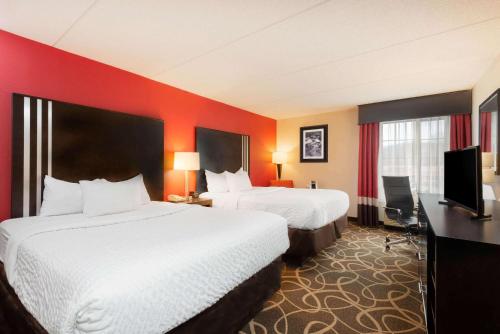 萨默斯维尔La Quinta Inn & Suites - New River Gorge National Park的酒店客房设有两张床和一台平面电视。