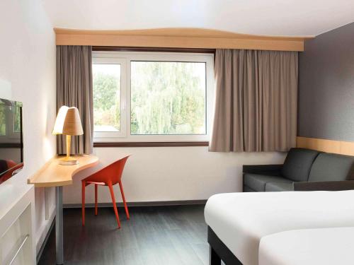 Thielle纳沙泰尔3宜必思酒店的酒店的客房 - 带一张床、椅子和窗户