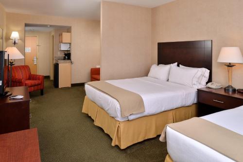大洋城大洋城智选假日酒店的酒店客房带一张大床和一把椅子