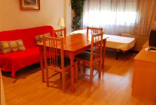 马德里戈雅75号公寓的客厅配有桌椅和沙发