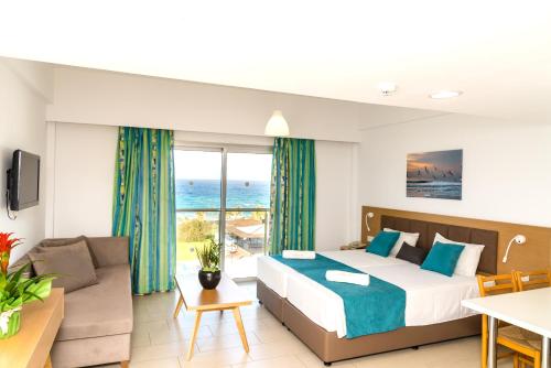 帕福斯Helios Bay Hotel and Suites的一间卧室设有一张床和一间客厅。