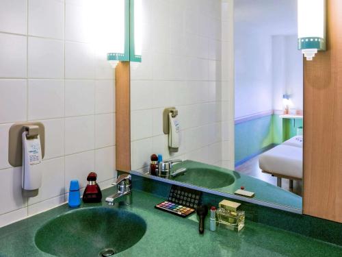 阿尔卡拉德荷那利斯Ibis Budget Madrid Alcalá de Henares La Dehesa的一间带绿色水槽和镜子的浴室