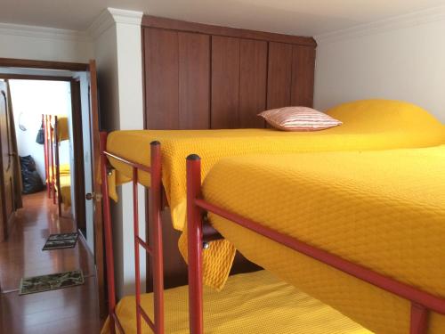 派帕Casa Vacacional La Estación Paipa的配有黄床单的客房内的两张双层床