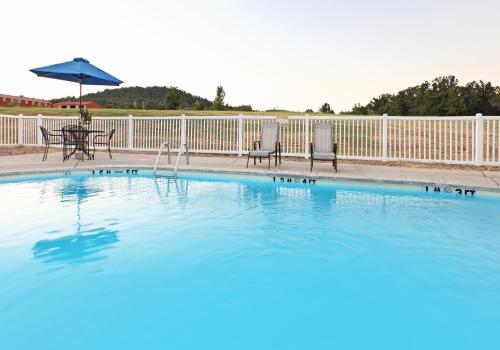 芒廷霍姆芒台豪姆智选假日套房酒店的一个带两把椅子和遮阳伞的游泳池