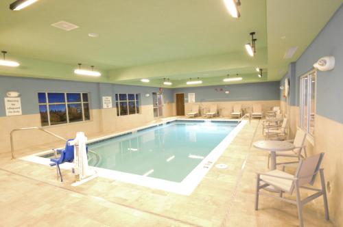 Perrysburg HeightsHoliday Inn Express & Suites Toledo South - Perrysburg, an IHG Hotel的医院里的一个大型游泳池,四周摆放着椅子