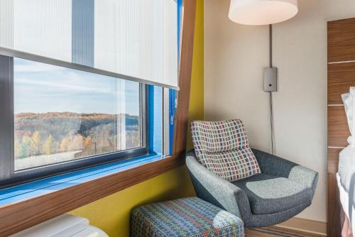 克拉里恩克拉里恩套房智选假日酒店的一间卧室配有椅子和窗户