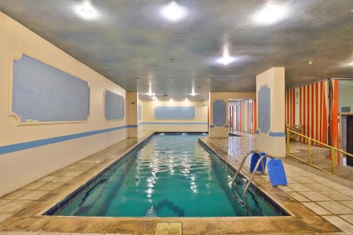 巴哈Al-faleh Hotel的一座位于大楼内的蓝色海水室内游泳池