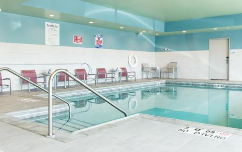 Rock Falls洛克福尔斯智选假日酒店的大楼内一个带桌椅的游泳池