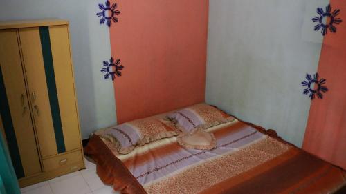 SermoHomestay ENDRO的墙上挂着蓝色花卉的一个小床