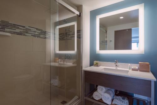 布鲁克林布鲁克林EVEN酒店的一间带水槽和玻璃淋浴的浴室