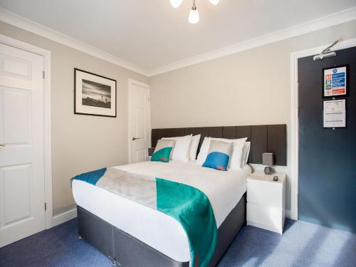 MurtonOYO The Village Inn, Murton Seaham的卧室配有蓝色和白色的大床