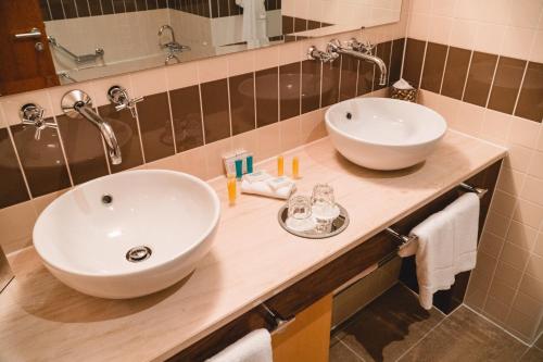阿森赖拉辛伍兹酒店的浴室在柜台上配有两个白色水槽