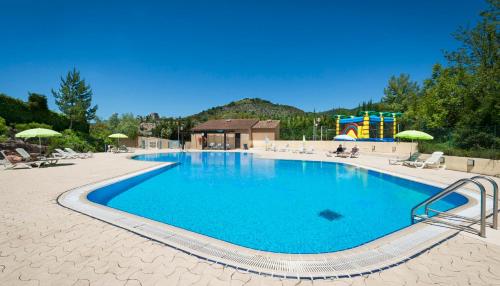 蒙布兰莱班Village Vacances Leo Lagrange的一个带椅子的大型游泳池和游乐场