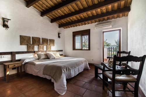 巴达霍斯El Pueblo de Leo的卧室配有1张床、1张桌子和1把椅子