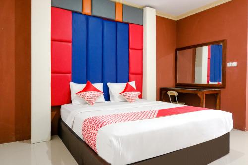 TrenggalekOYO Life 2966 Hotel Atriaz的一间卧室配有一张大床和色彩缤纷的床头板
