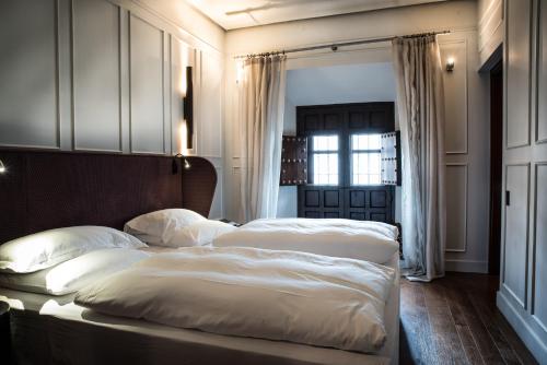 塞维利亚CoolRooms Palacio Villapanés的一间卧室设有两张带白色床单的床和窗户。