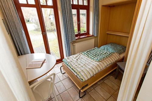 欧巴德伍斯图Ferienhaussiedlung Strandperlen Weidenhof 2a (Typ III)的小房间设有一张小床和一张桌子
