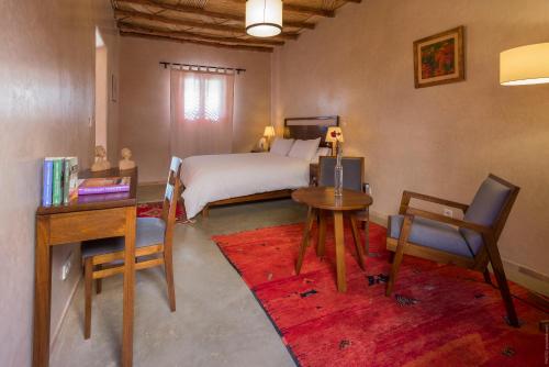 瓦尔扎扎特南面住宿加早餐旅馆的一间卧室配有一张床、一张桌子和一张桌子