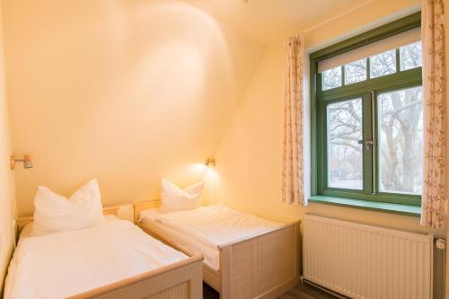 欧巴德伍斯图Ferienhaussiedlung Strandperlen Sanddornhof 3a (Typ VIII)的带窗户的客房内的两张床