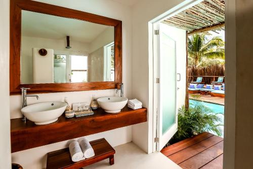 图卢姆Cabanas Tulum- Beach Hotel & Spa的浴室设有2个水槽和镜子