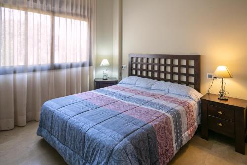 科尔多瓦拉卡斯蒂勒亚图里斯蒂克斯公寓酒店的一间卧室配有一张带蓝色毯子的床和窗户。