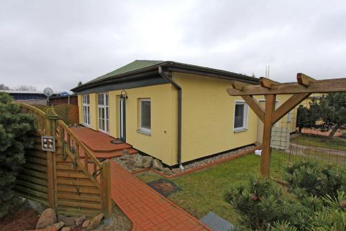 奥斯特西巴德钦诺维茨Ferienhaeuser Zinnowitz USE 3420的一座黄色的小房子,设有木栅栏