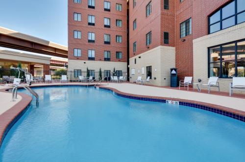 俄克拉何马城Staybridge Suites - Oklahoma City - Downtown, an IHG Hotel的大楼前的大型游泳池