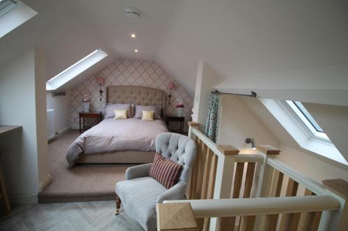 惠特比Granny's Attic at Cliff House Farm Holiday Cottages,的阁楼卧室设有一张床和一个楼梯
