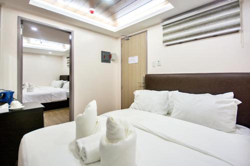 长滩岛Emerald Island Hotel的卧室配有一张白色大床和镜子