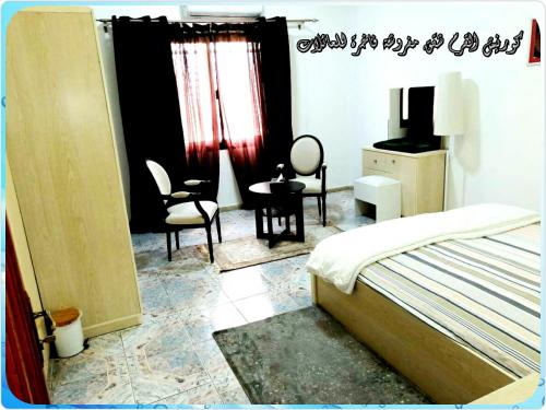 阿布扎比Mangrove Corniche Families Luxury Furniture Apartments的卧室配有一张床和一张桌子及椅子