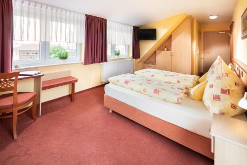诺德代希Hotel Atlantis的酒店客房配有一张床铺和一张桌子。