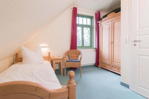 欧巴德伍斯图Ferienhaussiedlung Strandperlen Küstenhof 1d (Typ IV)的卧室配有床、椅子和窗户。