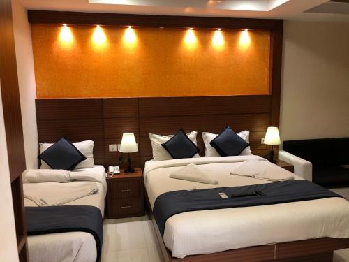 钦奈HOTEL SPARK RESIDENCY的一间卧室配有两张床和一个带灯的床头板
