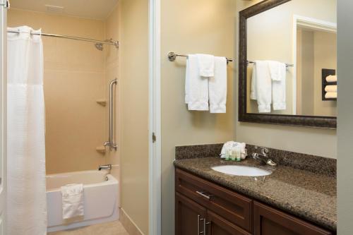 莫米Staybridge Suites Toledo/Maumee, an IHG Hotel的一间带水槽、浴缸和镜子的浴室