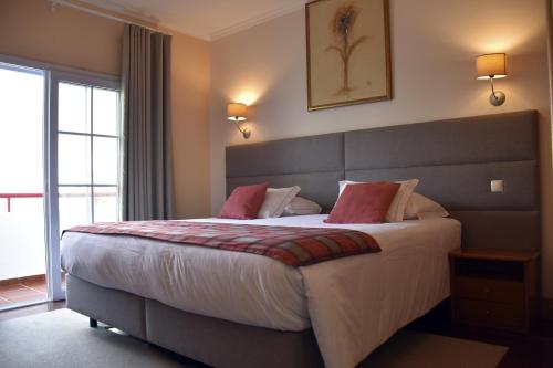 桑塔纳欧科尔莫酒店的一间卧室配有一张带红色枕头的大床